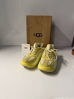 Front view of sneakers with bag and card