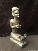 Front three-quarter view of seated Makonde ebony figure