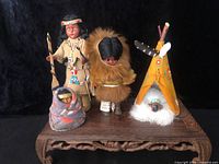 Front view of all dolls and teepee on display stand