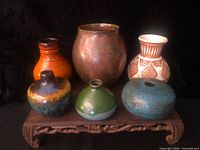 Front view of all six vases on stand