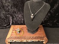 Bracelet, ring, and pendant displayed on stand