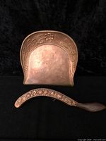 front view of copper crumb tray and brush showing embossed design