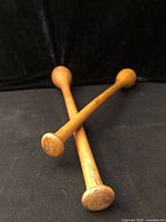 Two hardwood batons crossed showing flat knob ends