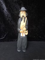 front view of full figurine showing attire, instrument, overall condition