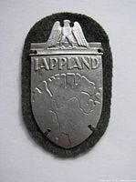 Front view of aluminium Lappland shield mounted on green felt