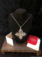 Pendant on chain displayed on bust with pouch, box and booklet