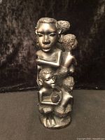 Front view of Makonde ebony Tree of Life sculpture showing foremost figures and overall form