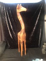 Front view of full-height giraffe sculpture against black backdrop