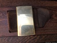 Front view of brass case inside felt pouch
