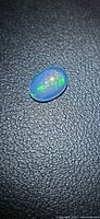 Front view of oval crystal jelly opal showing transparency and play of colour