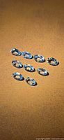 Ten light blue oval gemstones on tan surface