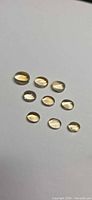 Group of 9 oval cabochon golden citrine stones on white background