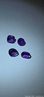 Top view of four faceted purple amethysts