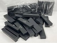 Pile of black Dazzly bracelet boxes with additional wrapped bundles behind