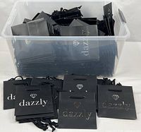 Clear tote filled with large quantity of black dazzly gift bags
