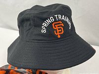 Side view of black bucket hat displaying embroidered Spring Training text and SF logo