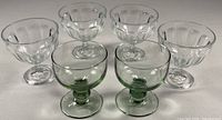 Group of six pedestal dessert bowls, four clear, two green-tinted