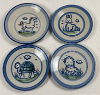 Group shot of all four Country Scene Blue plates showing animal motifs and condition