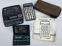 All three electronic devices, pouch, and manual displayed