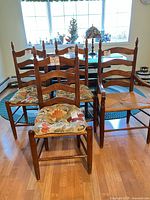Five ladder-back chairs with cushions in front of window
