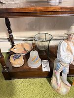All items grouped on shelf: figurine, bell, candle holder, fish dish, lidded trinket box