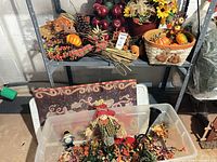 Overall lot on shelving showing baskets, faux fruit, florals, pinecones