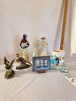 Group shot showing all 11 pieces including figurines, mug, frame, and glass items with scale ruler