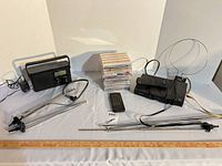 Group shot of entire lot: radio, DVD/VCR, antennas, remote, CDs, ruler for scale