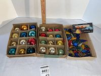 Overview of three trays: two with glass ball ornaments, one with loose C7 bulbs and NOMA sleeve