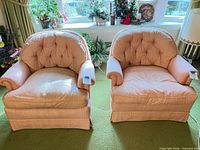 Front view of both peach-salmon tufted armchairs