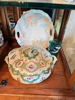 Covered serving dish with tray displayed in cabinet