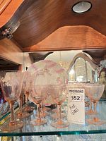 Group of pink pressed glass stemware and compote on shelf