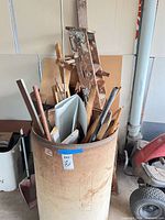 Ladder and barrel containing assorted wood pieces