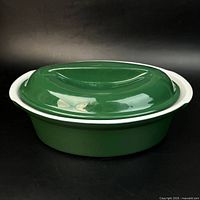 Side view of oval green stoneware casserole with lid