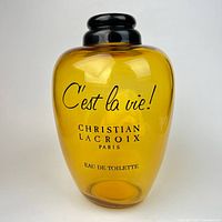 Front view of amber glass Christian Lacroix factice bottle showing full labeling