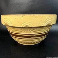 Side view of yellow ware bowl showing arc motif and brown bands