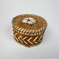 Front angled view of round birch bark quill box with lid on