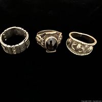 Front view of three sterling rings on black background