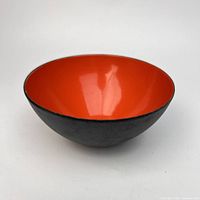 Oblique view showing red-orange interior and matte black exterior of bowl