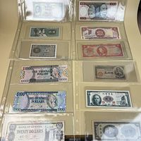 Overview of two binder pages showing eight assorted banknotes, front sides visible