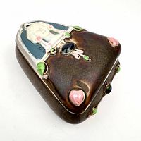 Triangular ceramic trinket box showing iridescent glaze and faux jewels