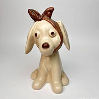 Front view of cream ceramic Toby Toothache dog with brown bandage detailing