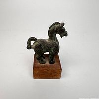Front view of bronze horse on wood base