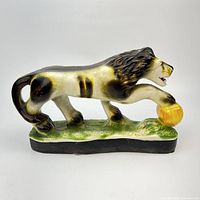 left side view of lion figurine showing base and pose