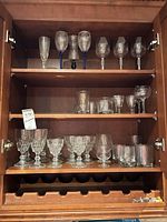 Entire cabinet section showing three shelves of assorted glassware