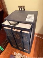 Slipcase holding three dictionary volumes with supplement and magnifier stored on top