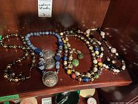 All four bead necklaces displayed on shelf