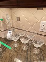 decanter and six coupe glasses on countertop