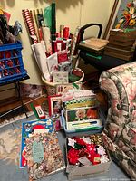 Overview of basket with wrapping paper rolls, bows, cards and bags