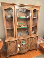 Front view of the oak china cabinet showing glass doors, drawers, lower cabinets